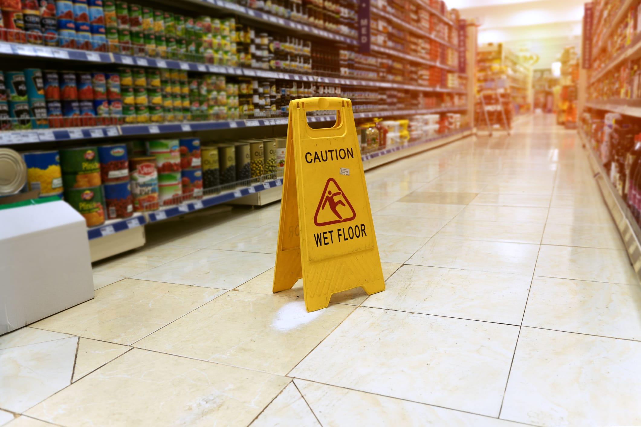 Yellow caution sign on a wet floor in a supermarket