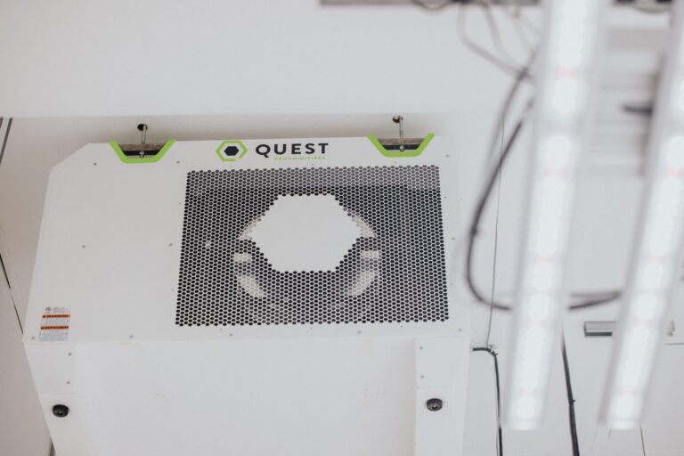 Ceiling-mounted dehumidifier with a hexagonal vent design, featuring a green and black logo.
