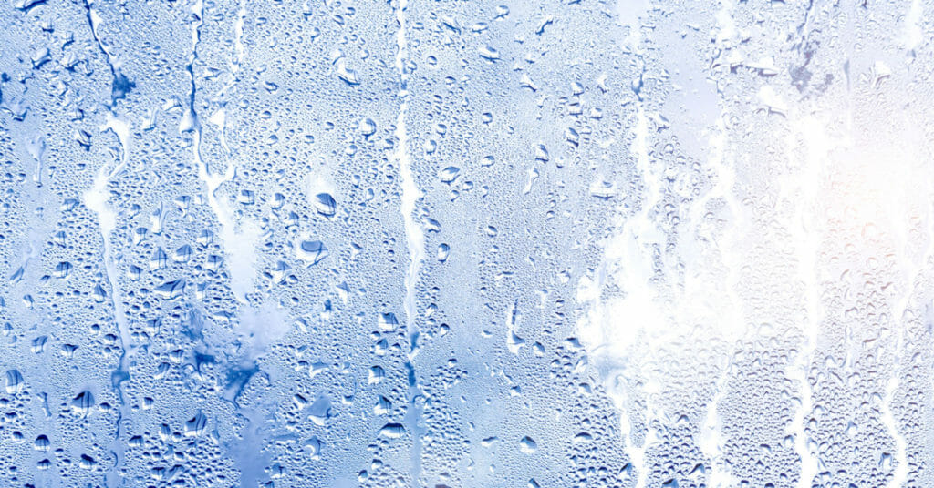 Condensation dripping down a glass pane